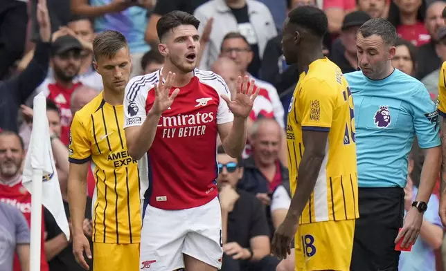 Arsenal's Declan Rice, left, discusses with Brighton's Danny Welbeck during the English Premier League soccer match between Arsenal and Brighton, at Emirates Stadium in London, Saturday, Aug. 31, 2024. (AP Photo/Alastair Grant)