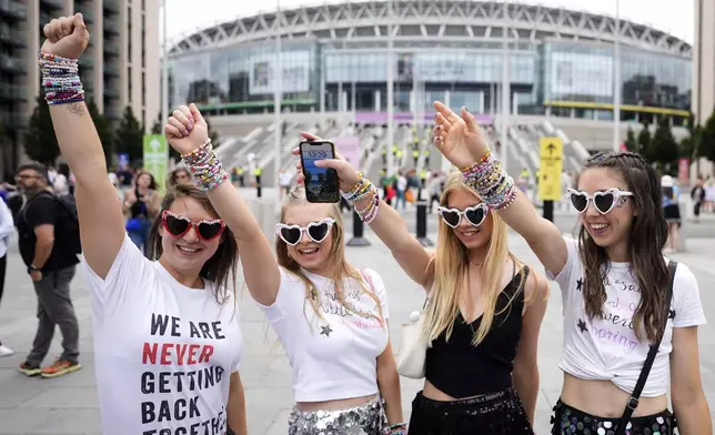 Fans of singer Taylor Swift, called Swifties, arrive at Wembley Stadium in London, Thursday, Aug. 15, 2024 for the first of five concerts of Taylor Swift's Eras Tour.(AP Photo/Alastair Grant)