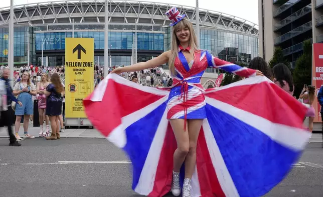 Fans of singer Taylor Swift, called Swifties, arrive at Wembley Stadium in London, Thursday, Aug. 15, 2024 for the first of five concerts of Taylor Swift's Eras Tour.(AP Photo/Alastair Grant)