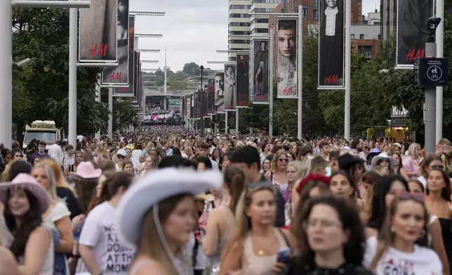 Fans of singer Taylor Swift, called Swifties, arrive at Wembley Stadium in London, Thursday, Aug. 15, 2024 for the first of five concerts of Taylor Swift's Eras Tour.(AP Photo/Alastair Grant)