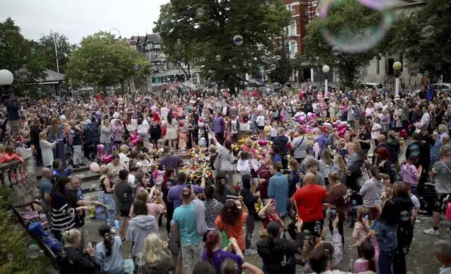 Members of the public place gather outside the Town Hall in Southport, England, Monday Aug. 5, 2024, ahead of a vigil to remember the victims of the stabbing attack last Monday. (Ryan Jenkinson/PA via AP)