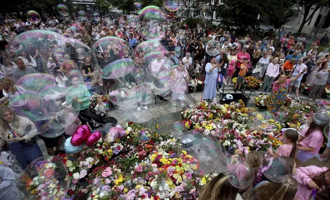 Members of the public take part in a vigil outside the Town Hall in Southport, England, Monday Aug. 5, 2024, to remember the victims of the stabbing attack last Monday. (Ryan Jenkinson/PA via AP)