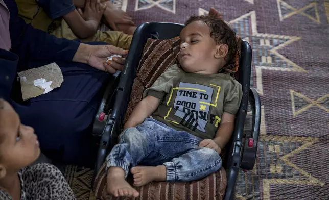 CORRECTS NAME: Displaced infant Abdel-Rahman Abu El-Jedian, who suffers from polio, sleeps at a makeshift tent camp in Deir al-Balah, central Gaza Strip, Tuesday, Aug. 27, 2024. (AP Photo/Abdel Kareem Hana)