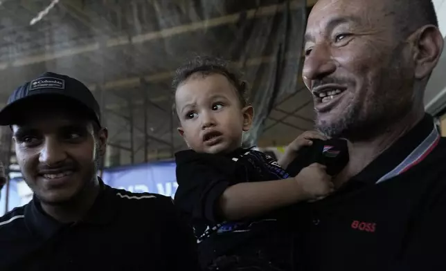 CORRECTS NAME Ismail Al-Qadi, left, holds one of the sons of his brother, Qaid Farhan Alkadi, 52, who was held hostage by Hamas militants in the Gaza Strip, as they stand at the entrance of the Soroka Medical Center in Beersheba, Israel, Tuesday, Aug. 27, 2024. (AP Photo/Tsafrir Abayov)