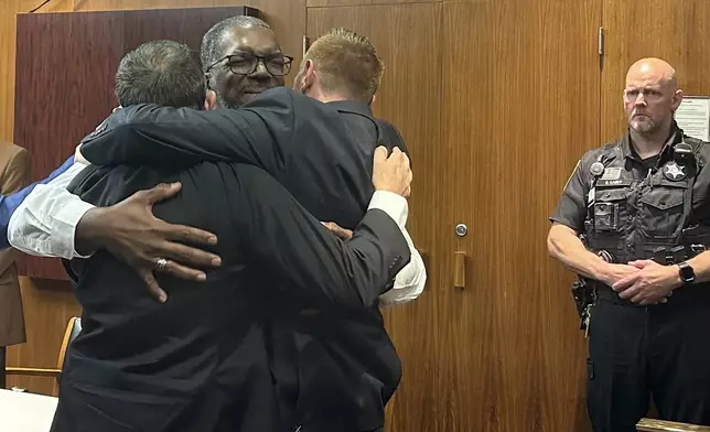 THIS CORRECTS TO PONTIAC, MICH., NOT DETROIT AS ORGINALLY SENT - Three security guards hug after a jury found them not guilty of involuntary manslaughter in a man's death at a Pontiac, Mich. mall more than 10 years ago, Friday, Aug. 23, 2024, in Pontiac, Mich. (AP Photo/EJ White)