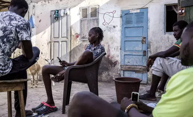 CORRECTS FAMILY NAME TO NDIAYE - Salamba Ndiaye, center, a 28-year-old who tried to migrate to Europe twice, is photographed in her family house in Thiaroye-Sur-Mer, Senegal, Friday, Aug. 23, 2024. Ndiaye is one of thousands of young Senegalese who try to flee poverty and the lack of job opportunities in the West African country each year to head to Spain. More than 22,300 people have landed on the Canary Islands from January to mid-August this year. (AP Photo/Annika Hammerschlag)