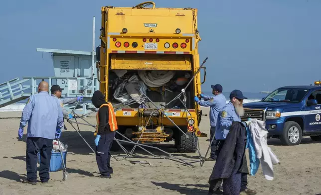 Los Angeles County Department of Beaches and Harbors workers assisted by police conduct a cleanup operation to remove homeless encampments at the Dockweiler State Beach in Playa del Rey, Los Angeles, Thursday, Aug. 22, 2024. (AP Photo/Damian Dovarganes)