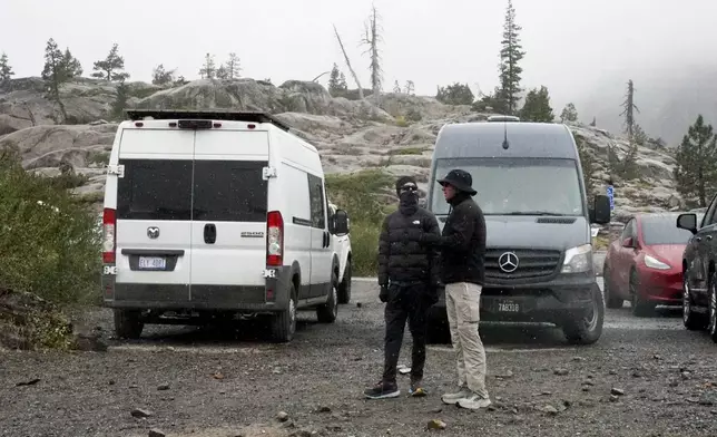 Snow comes down on two motorists Saturday, Aug. 24, 2024, in Donner Summit, Calif. (AP Photo/Brooke Hess-Homeier)