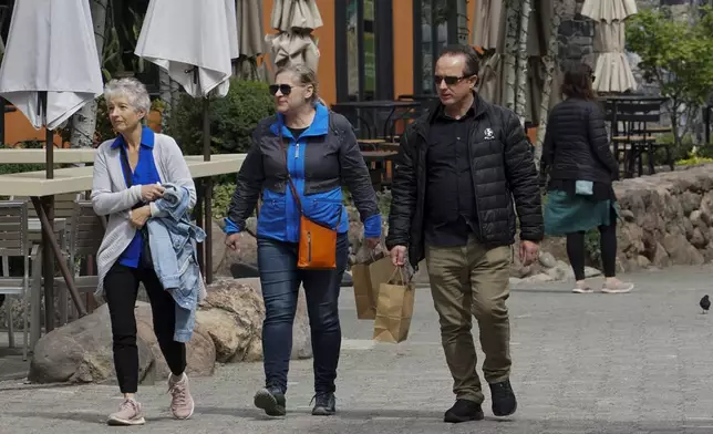 Visitors bundle up as temperatures drop ahead of a storm at the Palisades Tahoe Ski Resort Friday, Aug. 23, 2024, in Olympic Valley, Calif. (AP Photo/Brooke Hess-Homeier)