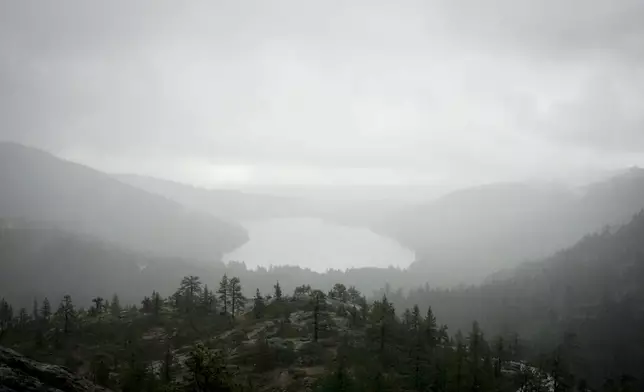 A storm occurs over Donner Lake seen from the Mt. Judah Loop Trail at Sugarbowl Ski Resort Saturday, Aug. 24, 2024, in Donner Summit, Calif. (AP Photo/Brooke Hess-Homeier)