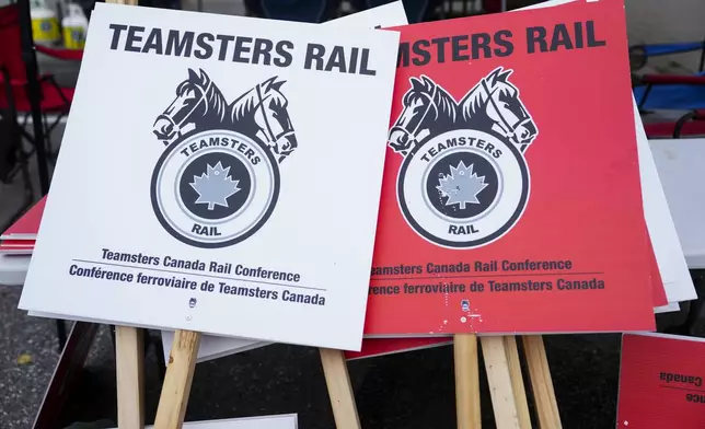 Teamsters Rail placards sit in a pile at a Canadian Pacific Kansas City (CPKC) rail yard in Smiths Falls, Ont., on Thursday, Aug. 22, 2024. (Sean Kilpatrick /The Canadian Press via AP)