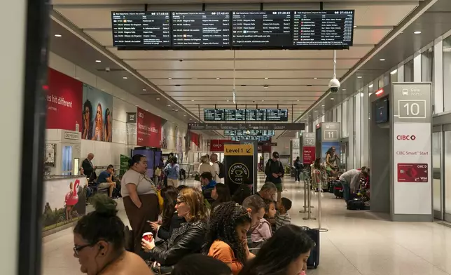 People wait inside at the Union Station bus terminal as a national rail shutdown causes delays in Toronto, Thursday, Aug. 22, 2024. (Paige Taylor White /The Canadian Press via AP)