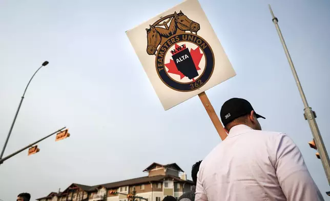 Teamsters Canada Rail Conference members picket outside the CPKC headquarters in Calgary, Alta., Friday, Aug. 23, 2024. (Jeff McIntosh/The Canadian Press via AP)