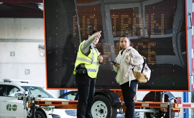 Commuters at the GO Bus Terminal Aug. 22, 2024 gets instructions as train service from Hamilton has been interrupted by the labor dispute with the two major Canadian railways on Thursday, Aug. 22, 2024 in Hamilton, Ontario. (Peter Power/The Canadian Press via AP)