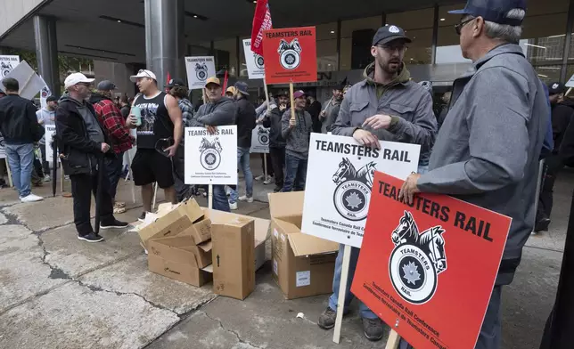 Rail workers picket in front of Canadian National headquarters on the first day of a nationwide rail shutdown, after workers were locked out by CN and CPKC when new contract agreements weren't reached by the midnight deadline, in Montreal, Thursday, Aug. 22, 2024. (Ryan Remiorz /The Canadian Press via AP)