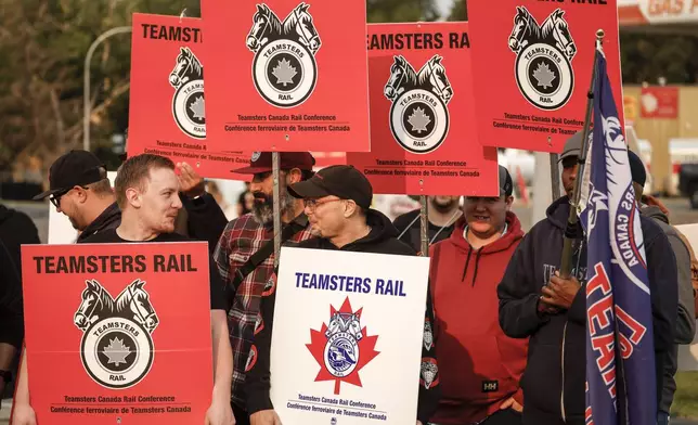 Teamsters Canada Rail Conference members picket outside the CPKC headquarters in Calgary, Alta., Friday, Aug. 23, 2024.(Jeff McIntosh /The Canadian Press via AP)