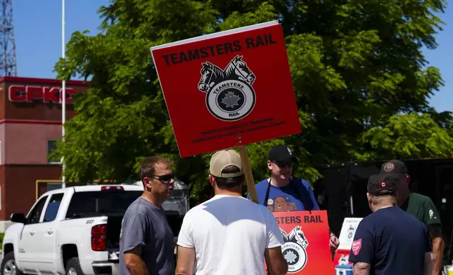 Picketer carry Teamsters Rail placards at a Canadian Pacific Kansas City (CPKC) rail yard in Smiths Falls, Ontario, Canada, Thursday, Aug. 22, 2024, (Sean Kilpatrick/The Canadian Press via AP)