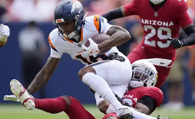 Denver Broncos wide receiver Troy Franklin, top, is tackled by Arizona Cardinals cornerback Darren Hall during the first half of a preseason NFL football game Sunday, Aug. 25, 2024, in Denver. (AP Photo/David Zalubowski)