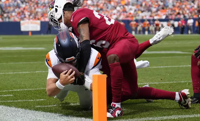 Denver Broncos quarterback Zach Wilson, left, gets tackled just short of the endzone by Arizona Cardinals cornerback Bobby Price, right, during the first half of a preseason NFL football game Sunday, Aug. 25, 2024, in Denver. (AP Photo/Jack Dempsey)