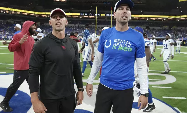 Arizona Cardinals head coach Jonathan Gannon, left, pauses with Indianapolis Colts head coach Shane Steichen, right, after a preseason NFL football game, Sunday, Aug. 18, 2024, in Indianapolis. The Colts won 21-13. (AP Photo/Michael Conroy )