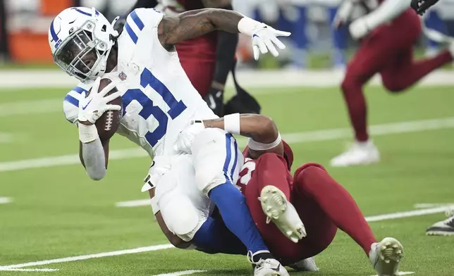 Indianapolis Colts running back Tyler Goodson (31) gets pulled down by Arizona Cardinals safety Dadrion Taylor-Demerson during the first half of a preseason NFL football game, Saturday, Aug. 17, 2024, in Indianapolis. (AP Photo/Michael Conroy)