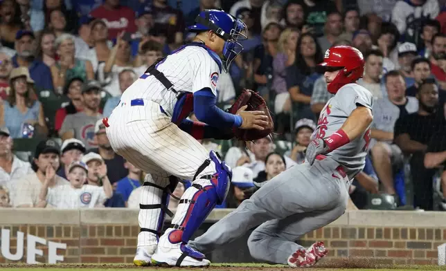 St. Louis Cardinals' Paul Goldschmidt, right, is safe at home plate as Chicago Cubs catcher Miguel Amaya, left, makes a late tag during the seventh inning of a baseball game Thursday, Aug. 1, 2024, in Chicago. (AP Photo/David Banks)