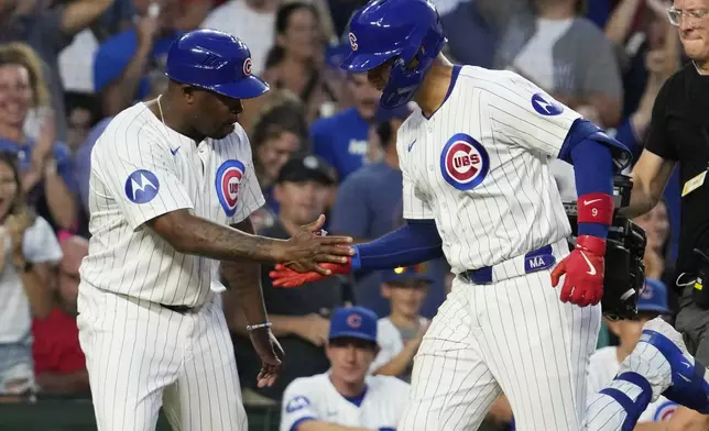 Chicago Cubs' Miguel Amaya, right, celebrates with third base coach Willie Harris, left, after hitting a solo home run during the sixth inning of a baseball game against the St. Louis Cardinals in Chicago, Sunday, Aug. 4, 2024. (AP Photo/Nam Y. Huh)