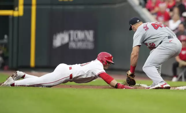 Cincinnati Reds' TJ Friedl is picked off first as St. Louis Cardinals' Paul Goldschmidt makes the tag during the third inning of a baseball game, Tuesday, Aug. 13, 2024, in Cincinnati. (AP Photo/Kareem Elgazzar)