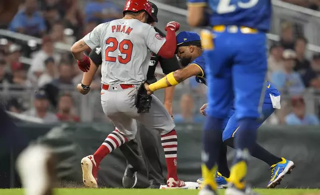 St. Louis Cardinals' Tommy Pham (29) is tagged out at third base by Minnesota Twins shortstop Willi Castro, back right, during the seventh inning of a baseball game Friday, Aug. 23, 2024, in Minneapolis. (AP Photo/Abbie Parr)