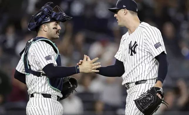 New York Yankees relief pitcher Clay Holmes, right, and catcher Austin Wells, right, congratulate each other after a baseball game against the St. Louis Cardinals, Friday, Aug. 30, 2024, in New York. (AP Photo/Adam Hunger)