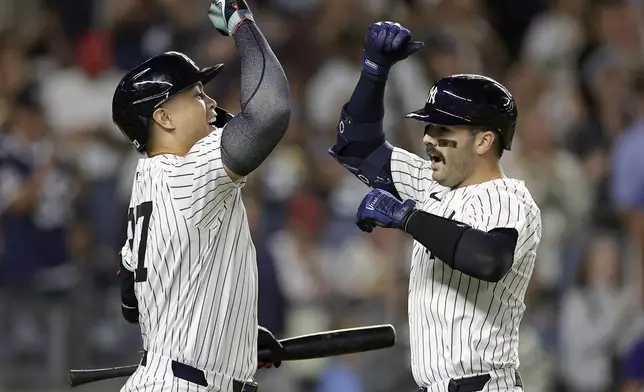 New York Yankees' Austin Wells is congratulated by Giancarlo Stanton, left, after hitting a two-run home run during the eighth inning of a baseball game against the St. Louis Cardinals, Friday, Aug. 30, 2024, in New York. The Yankees won 6-3. (AP Photo/Adam Hunger)