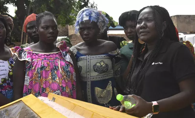 Adele Noudjilembaye, right, a local agriculturist and an activist talks to other women in a village of Binmar, Chad, Friday, July 19, 2024. (AP Photo/Robert Bociaga)