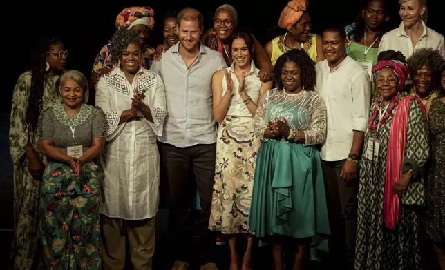 Prince Harry and his wife Meghan pose for a group photo after a forum on Afro women and power in Cali, Colombia, Sunday, Aug. 18, 2024. (AP Photo/Ivan Valencia)