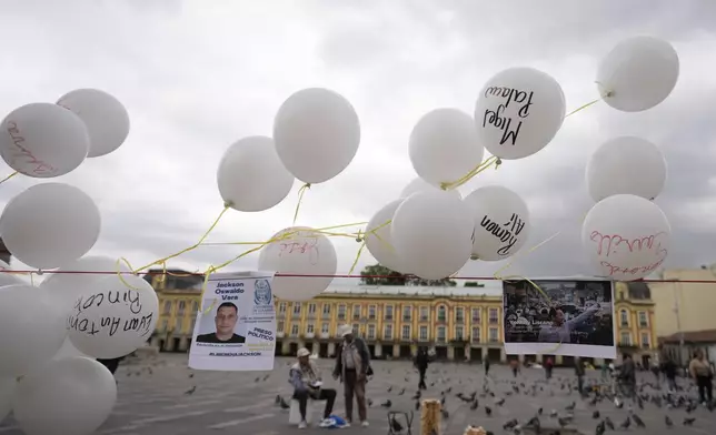 Photos and balloons representing people detained by Venezuelan security forces after Venezuela's presidential election hang at Bolivar square in Bogota, Colombia, Wednesday, Aug. 28, 2024, during a protest against the reelection of President Nicolas Maduro one month after the disputed vote which the opposition says it won by a landslide. (AP Photo/Fernando Vergara)