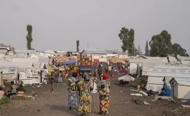 Women walk in the Bulengo refugee camp in Goma, Congo, after the World Health Organization had declared Thursday, Aug, 15, 2024, the increasing spread of mpox in Africa a global health emergency, warning the virus might ultimately spill across international borders. (AP Photo/Moses Sawasawa)