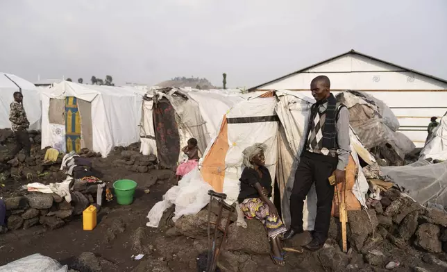 Faustin Mahoro, head of the Bulengo refugee camp in Goma, Congo, speaks with Sarah Bagheni after the World Health Organization had declared Thursday, Aug, 15, 2024, the increasing spread of mpox in Africa a global health emergency, warning the virus might ultimately spill across international border. (AP Photo/Moses Sawasawa)