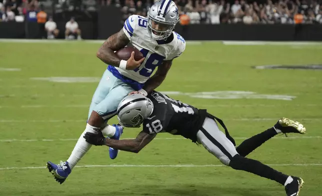 Dallas Cowboys quarterback Trey Lance is tackles by Las Vegas Raiders cornerback Jack Jones (18) during the first half of an NFL preseason football game, Saturday, Aug. 17, 2024, in Las Vegas. (AP Photo/Rick Scuteri)