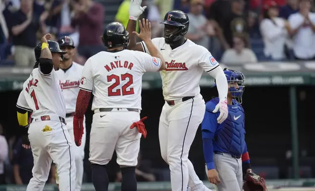 Cleveland Guardians' Jhonkensy Noel, second from right, celebrates after his home run with teammates Jose Ramirez (11) and Josh Naylor (22) in near Chicago Cubs catcher Miguel Amaya, right, in the fourth inning of a baseball game Monday, Aug. 12, 2024, in Cleveland. (AP Photo/Sue Ogrocki)