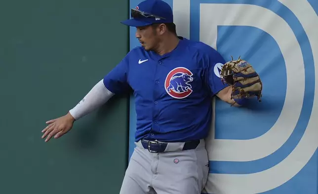 Chicago Cubs right fielder Seiya Suzuki collides with the outfield wall after catching a fly ball hit for an out against Cleveland Guardians' David Fry in the second inning of a baseball game Monday, Aug. 12, 2024, in Cleveland. (AP Photo/Sue Ogrocki)