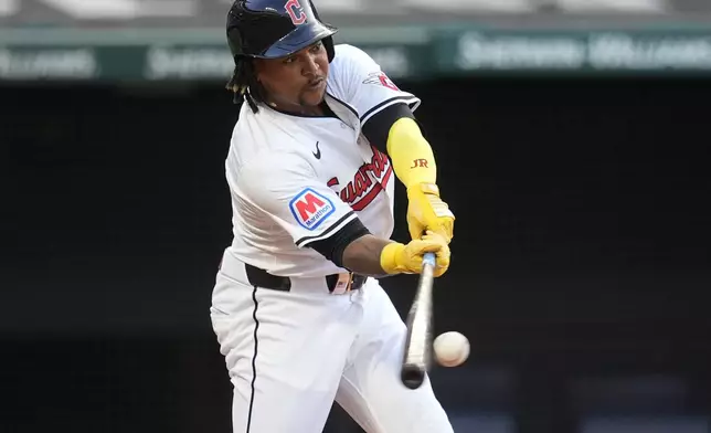 Cleveland Guardians' Jose Ramirez bats and makes it safely to first base on a fielding error by Chicago Cubs third baseman Isaac Paredes in the fourth inning of a baseball game Monday, Aug. 12, 2024, in Cleveland. (AP Photo/Sue Ogrocki)