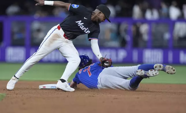 Miami Marlins second base Vidal Bruján, left, is unable to make the tag as Chicago Cubs' Dansby Swanson (7) steals second base during the fourth inning of a baseball game, Friday, Aug. 23, 2024, in Miami. (AP Photo/Wilfredo Lee)