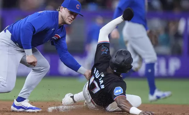 Chicago Cubs second baseman Nico Hoerner, left, tags out Miami Marlins' Vidal Bruján after Bruján attempted to steal second during the fifth inning of a baseball game, Friday, Aug. 23, 2024, in Miami. (AP Photo/Wilfredo Lee)