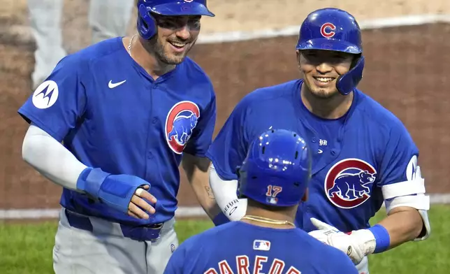 Chicago Cubs' Seiya Suzuki, right, celebrates with Mike Tauchman, left, and Isaac Paredes as he returns to the dugout after hitting a two-run home run off Pittsburgh Pirates starting pitch Jared Jones during the fourth inning of a baseball game in Pittsburgh, Tuesday, Aug. 27, 2024. (AP Photo/Gene J. Puskar)