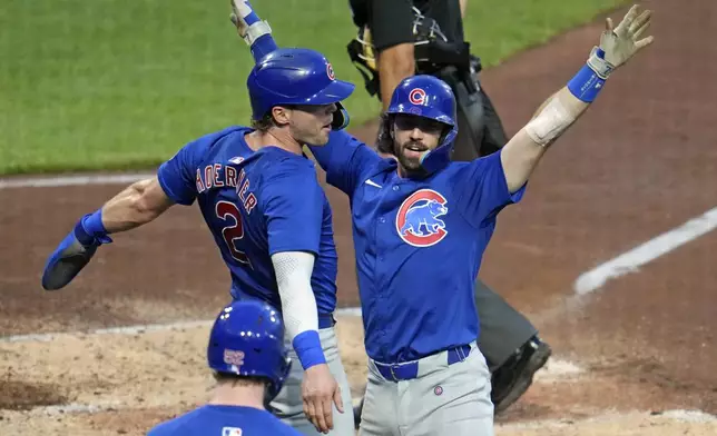 Chicago Cubs' Dansby Swanson, right, celebrates with Nico Hoerner, left, as he returns to the dugout after hitting a two-run home run off Pittsburgh Pirates starting pitch Jared Jones during the fourth inning of a baseball game in Pittsburgh, Tuesday, Aug. 27, 2024. (AP Photo/Gene J. Puskar)