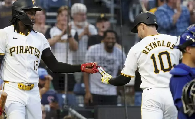 Pittsburgh Pirates' Bryan Reynolds, right, is greeted by Oneil Cruz, left, after he hit a home run during the third inning of a baseball game against the Chicago Cubs, Monday, Aug. 26, 2024, in Pittsburgh. (AP Photo/Matt Freed)