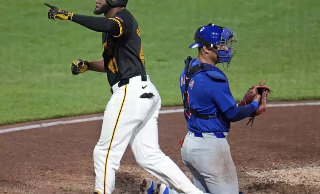 Pittsburgh Pirates' Bryan De La Cruz (41) heads back to the dugout past Chicago Cubs catcher Miguel Amaya after hitting a solo home run off relief pitcher Nate Pearson during the sixth inning of a baseball game in Pittsburgh, Tuesday, Aug. 27, 2024. (AP Photo/Gene J. Puskar)