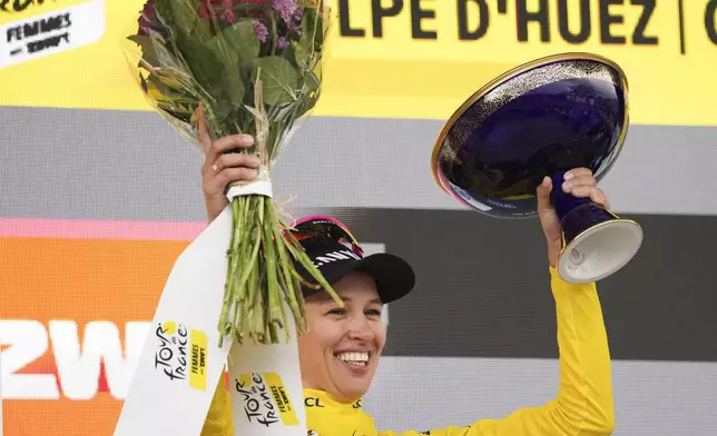 Overall winner Katarzyna Niewiadoma of Poland celebrates on the podium after the eighth stage of the Tour de France Women cycling race with start in Le Grand-Bornand and finish in Alpe d'Huez, France, Sunday, Aug. 18, 2024. (AP Photo/Peter Dejong)