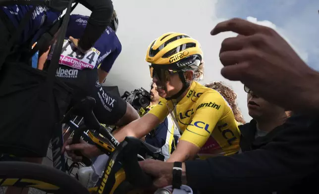 Overall winner Katarzyna Niewiadoma of Poland crosses the finish line to retain her yellow jersey in the eighth stage of the Tour de France Women cycling race with start in Le Grand-Bornand and finish in Alpe d'Huez, France, Sunday, Aug. 18, 2024. (AP Photo/Peter Dejong)