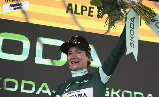 Marianne Vos of The Netherlands, wearing the best sprinter's green jersey, celebrates on the podium after the eighth stage of the Tour de France Women cycling race with start in Le Grand-Bornand and finish in Alpe d'Huez, France, Sunday, Aug. 18, 2024. (AP Photo/Peter Dejong)