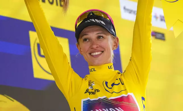 Katarzyna Niewiadoma of Poland, wearing the overall leader's yellow jersey, celebrates on the podium after the seventh stage of the Tour de France Women cycling race with start in Champagnole and finish in Le Grand-Bornand, France, Saturday, Aug. 17, 2024. (AP Photo/Peter Dejong)